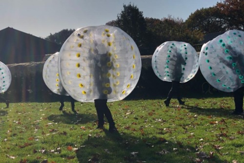 Kinderen die voetballen in bubbel ballen 